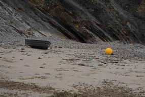 Yellow baloon and boat on beach sand rocks view