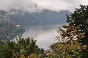 white clouds over a mountain lake