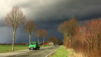 Auto on the road against a stormy sky