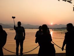people silhouettes at beautiful sunset lake landscape