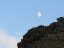 moon in the blue sky over the mountains