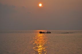 boat with tourists in the sea at sunset