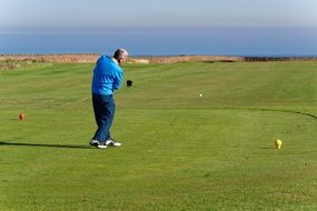 man in blue suit plays golf