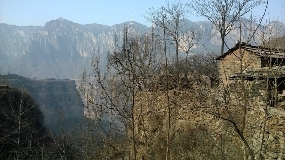 old stone buildings among trees on rock