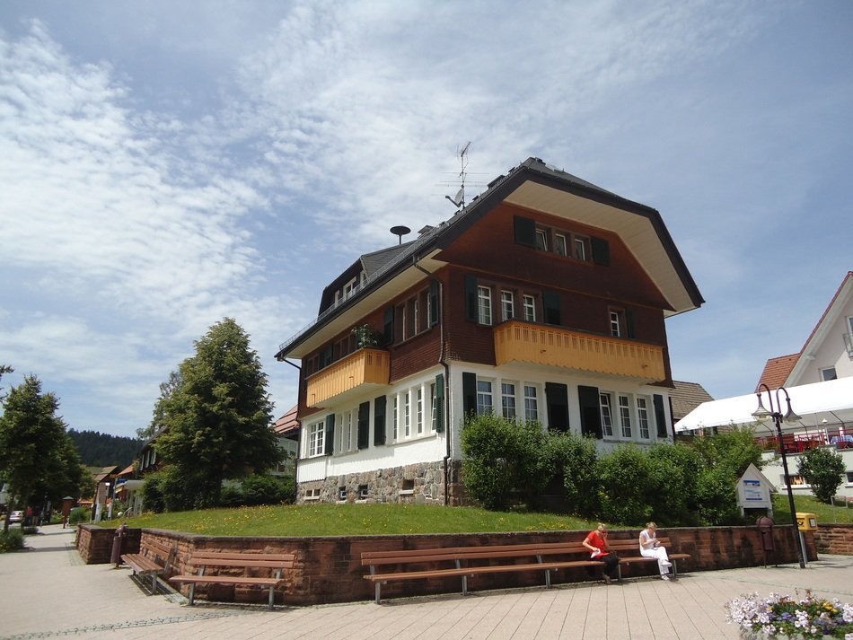 people on bench at apartments, germany, black forest