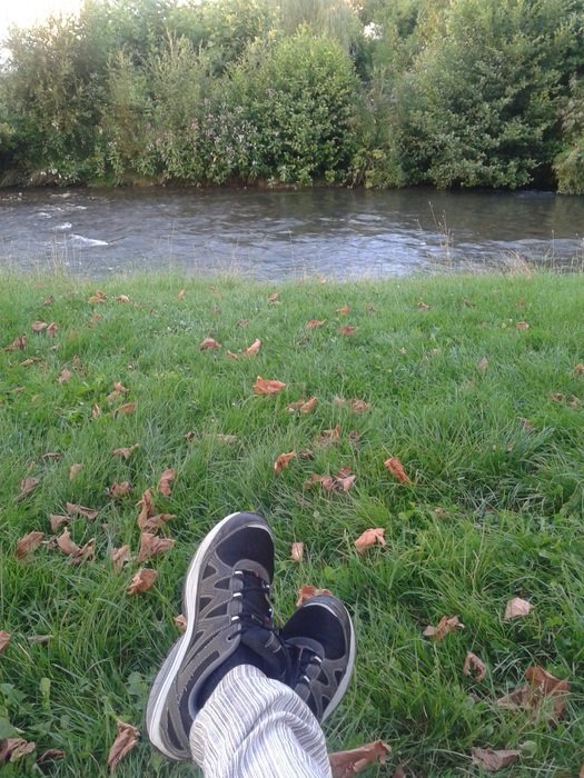 legs in sneakers on green grass