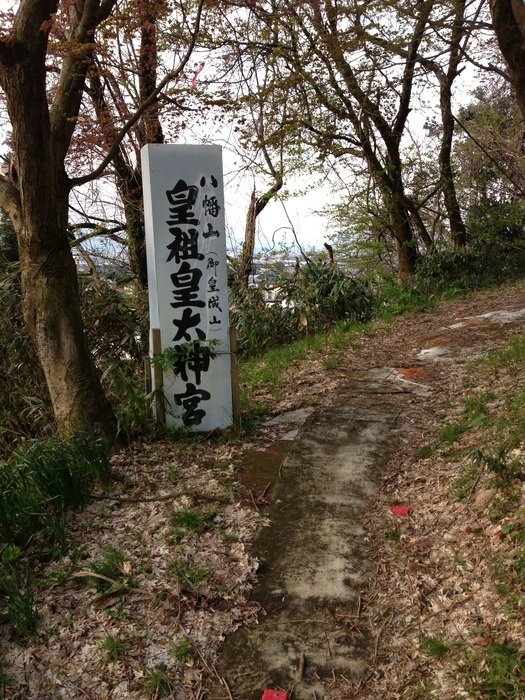 Black and white oriental hieroglyphical writing on sign at path in the beautiful and colorful forest