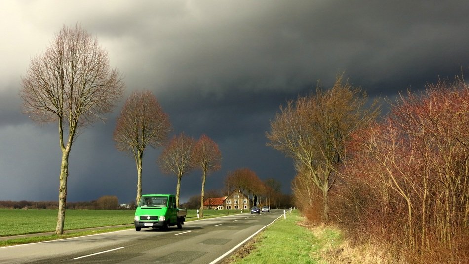 Auto on the road against a stormy sky