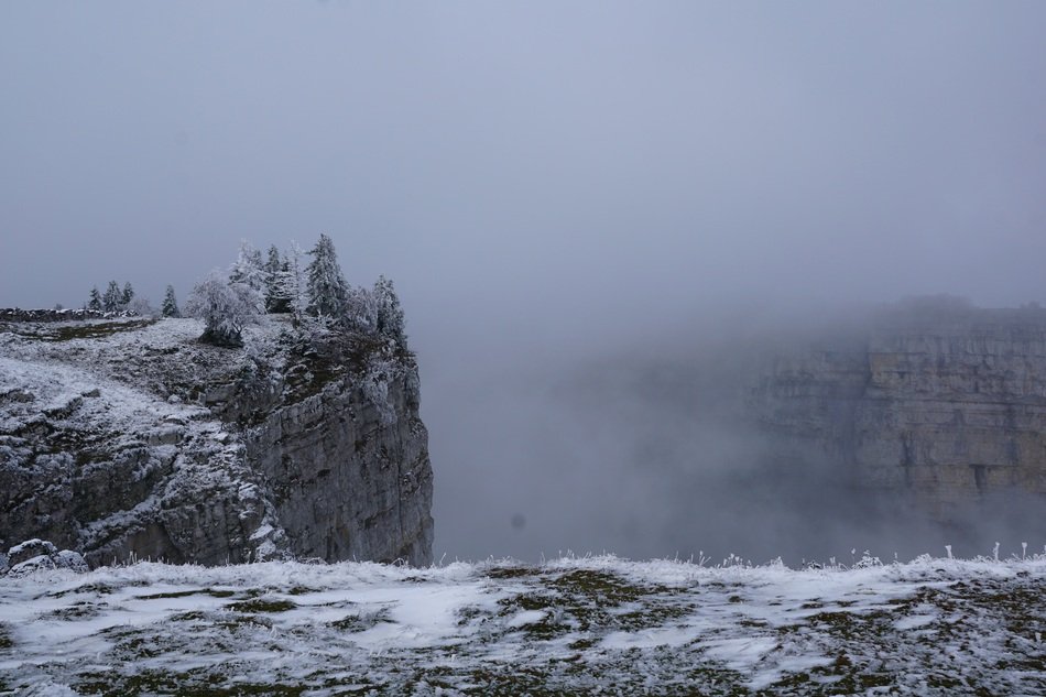 landscape of creux du van abyss in the fog