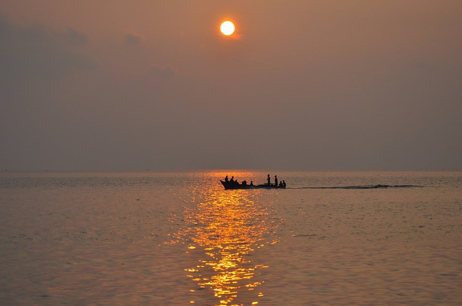 boat with tourists in the sea at sunset