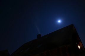 full moon in night sky over house