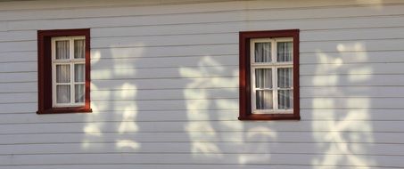 two red framed windows on white facade