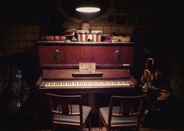 two chairs at vintage piano in dark interior
