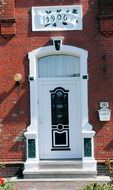 white front door of a brick building