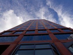 blue glass facade of a skyscraper with burgundy accents