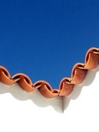 brick roof panels against a bright blue sky