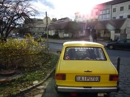 yellow retro car parked on the street in esztergom