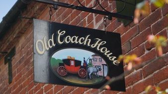 hotel sign Old coach house on a brick wall