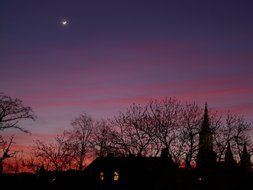 star in evening sky above silhouette of old town