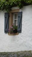 grey shutters on the windows of an old rural house