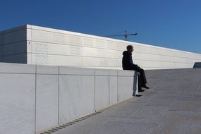 teenager is sitting on the parapet of the Opera House in Norway