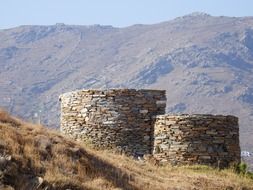 two round towers on a background of mountains in Greece