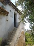 external stone staircase at wall of old farmhouse