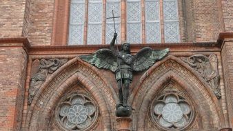 angel with a cross as a sculpture on a church