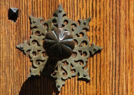 Decorative door handle in the form of a metallic stars