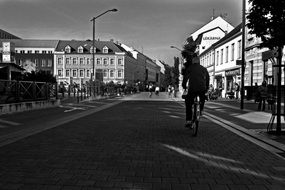 black and white photo of a cyclist on the road