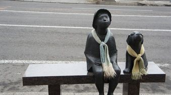 statue of man and dog on a bench in japan