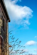 photo of part of the facade of the building and blue sky with clouds