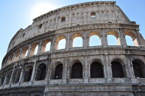 ancient wall of colosseum at blue sky, italy, rome