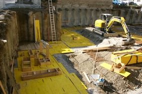 excavator near yellow formwork