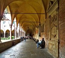 people resting in aged arcade