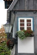truss building with a lantern and pots of flowers