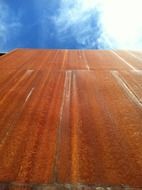 tall rusty building with a background of a blue sky