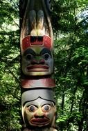 colorful totem pole among green trees