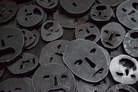 A lot of metal faces in a pile