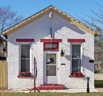 A small white house decorated for Christmas