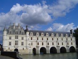 chenonceau castle over the river at blue sky background with white clouds