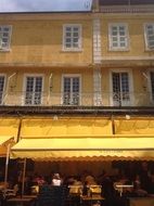 cafe on the ground floor of a yellow building in Arles, France