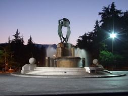 fountain with sculpture at dusk, italy, l'aquila