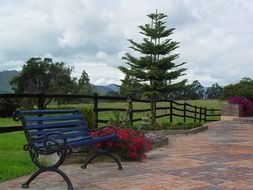 cobblestone walkway bench flowers trees