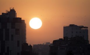 hot sun over the silhouettes of the evening city