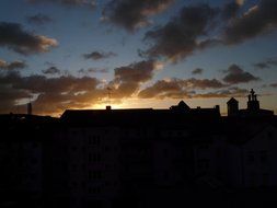 city buildings silhouette beneath clouds