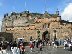 people in a square near a castle in scotland