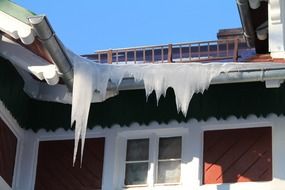 snow icicles on the roof of the house