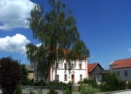 summer landscape with birch trees, houses and blue sky, germany, bavaria