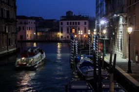 Illuminated canal in venice by night